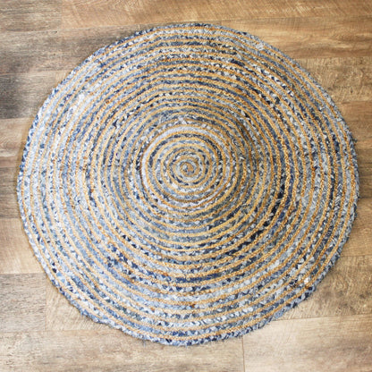Round woven rug with concentric circle pattern on a wooden floor