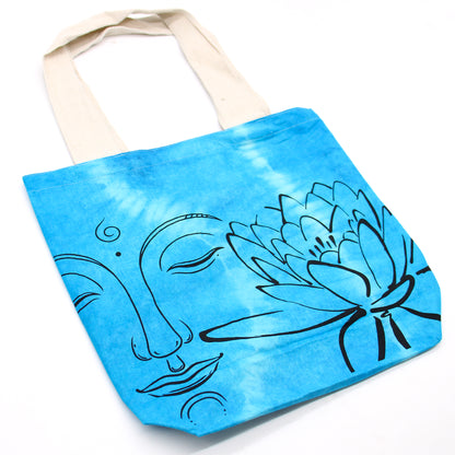 Tote bag with blue tie-dye design featuring a face and lotus flower on a white background