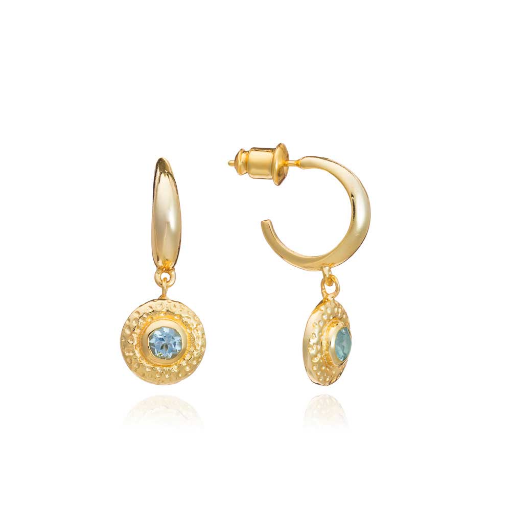 Gold hoop earrings with blue gemstones on a white background