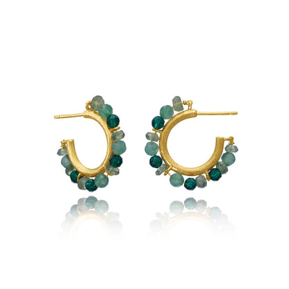 Gold hoop earrings with green gemstones on a white background