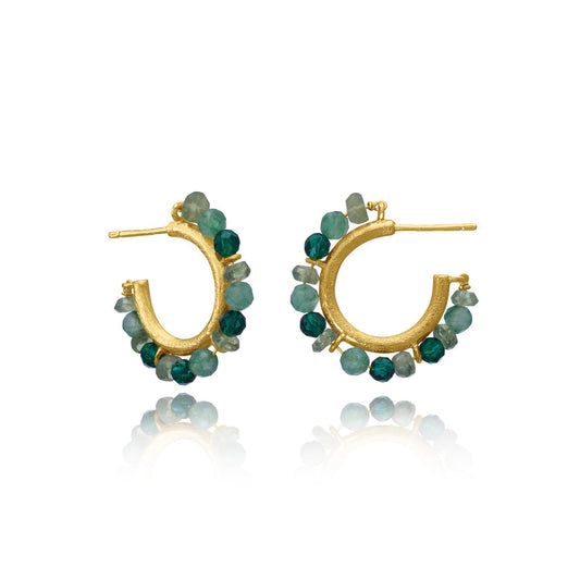 Gold hoop earrings with green gemstones on a white background