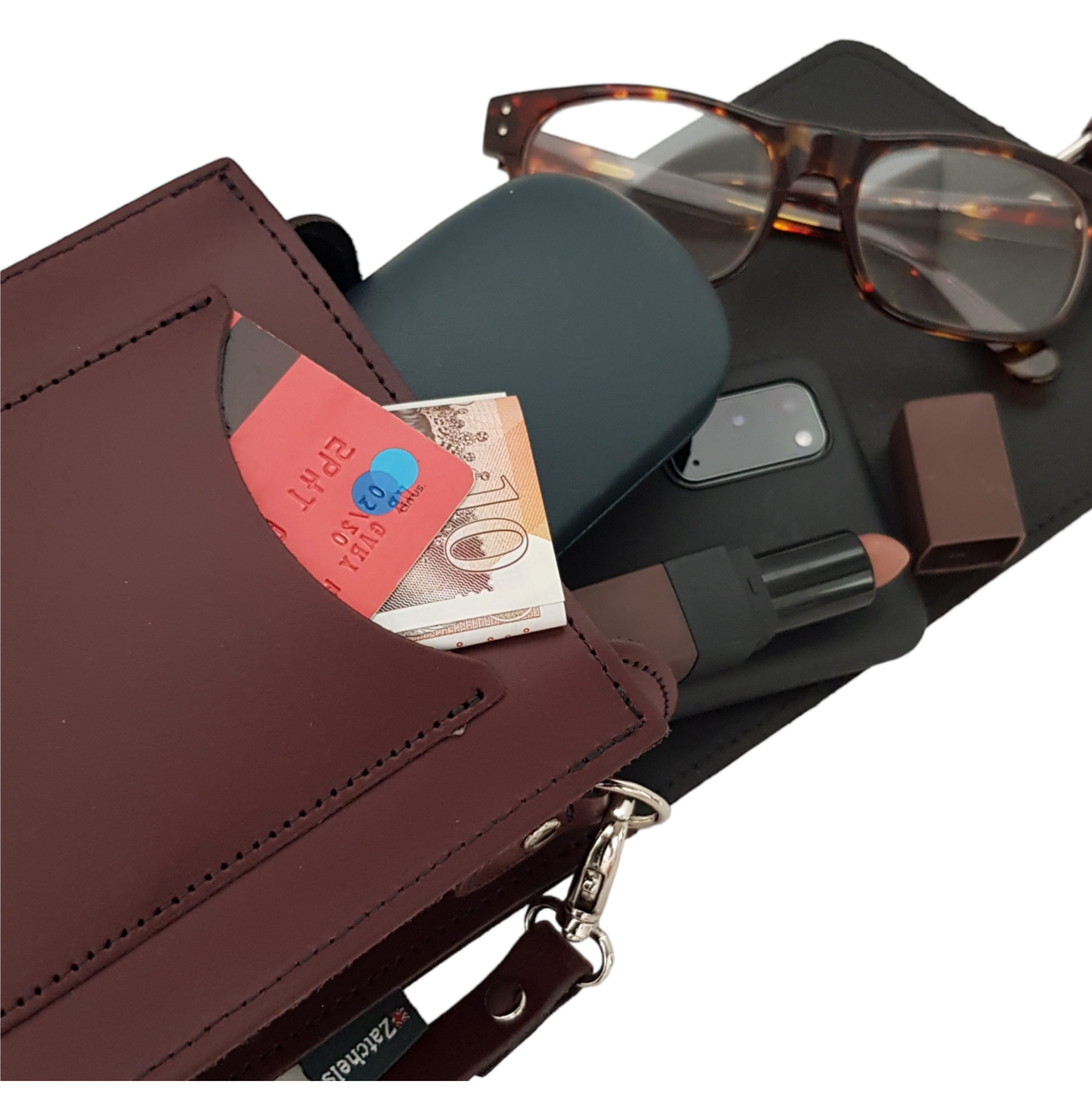 Brown leather wallet with money, sunglasses, phone case, and lip balm on a white background