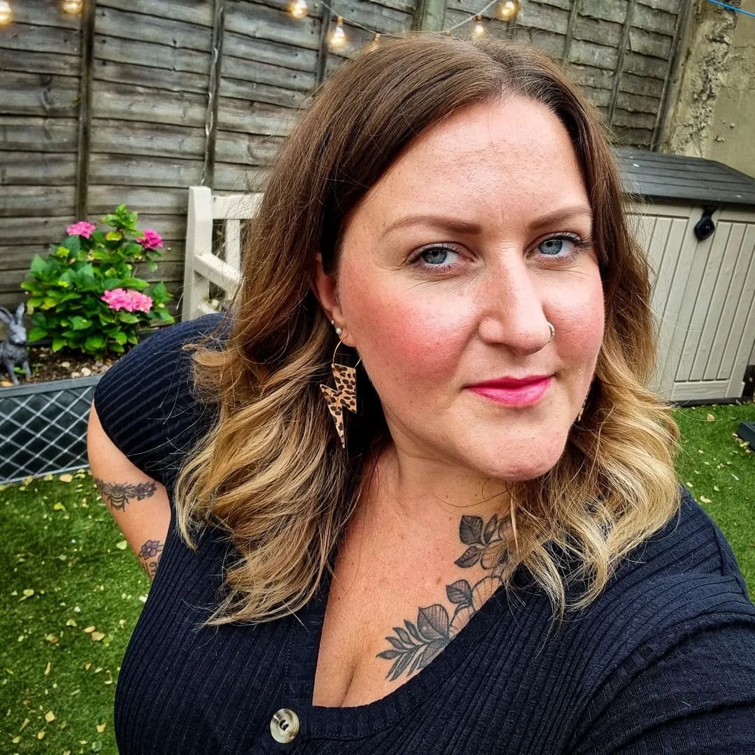 Woman with tattoos outdoors in a garden setting