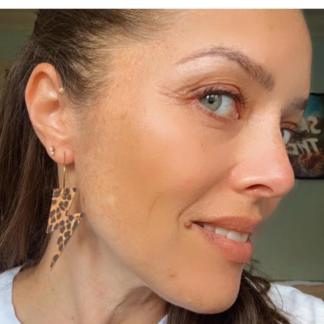 Close-up of a woman wearing leopard print earrings.