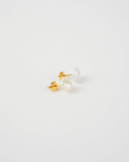 Pair of pearl stud earrings on a light gray background