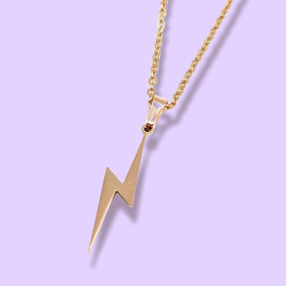 Gold lightning bolt pendant necklace on a light purple background