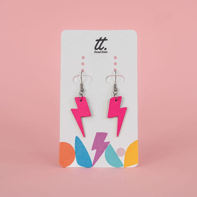 Pair of pink lightning bolt earrings on a branded card against a pink background