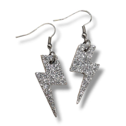 Silver glittery lightning bolt earrings on a white background