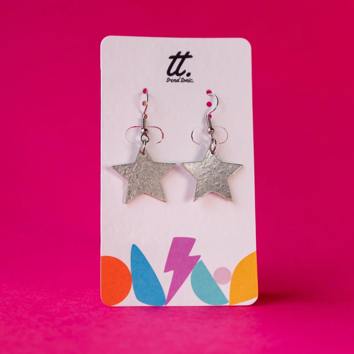 Star-shaped earrings on a branded card with a pink background