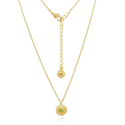 Gold necklace with a green gemstone pendant on a white background