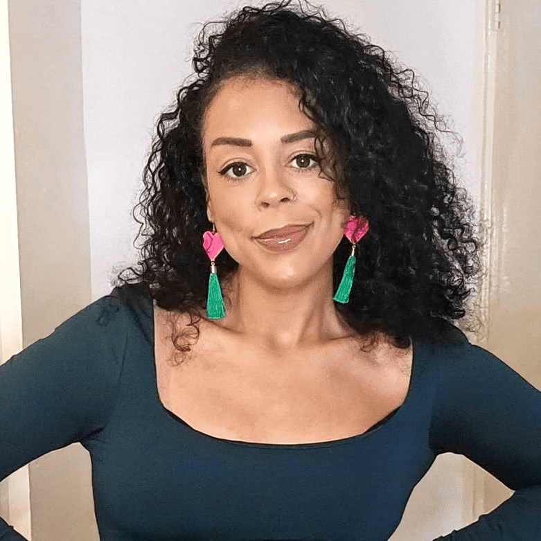 Woman wearing colorful earrings with a neutral background