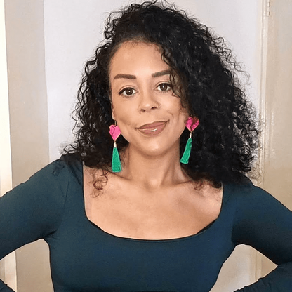 Woman wearing colorful earrings with a neutral background