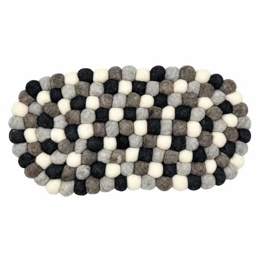 Grey felt ball oval centre mat seen from above, in charcoal, grey, taupe and cream wool balls