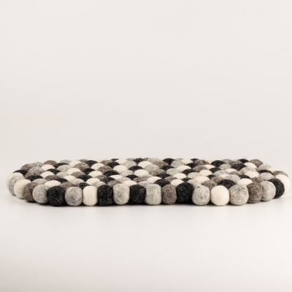 Side view of the grey felt ball oval mat showing its thickness