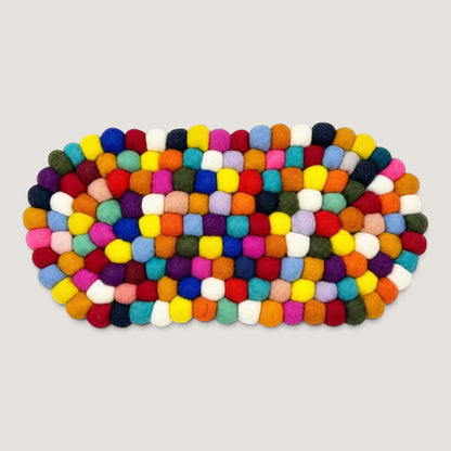 Multicolour felt ball oval centre mat seen from above, in a rainbow mix of wool balls
