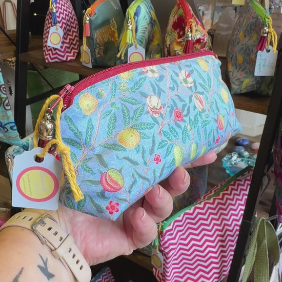 Hand turning the Garden Fruits pencil case to show the fruit print, zip and tassel in the Apricot Moon shop