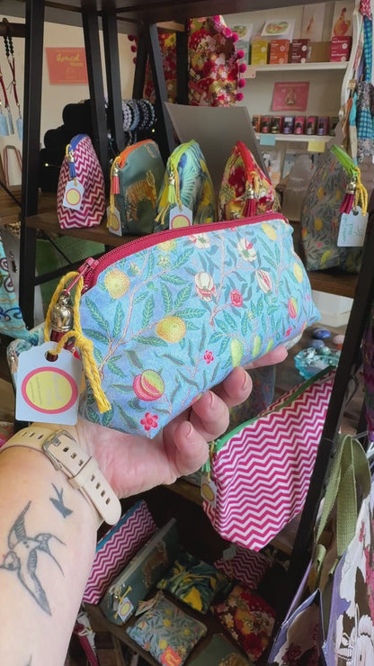 Hand turning the Garden Fruits pencil case to show the fruit print, zip and tassel in the Apricot Moon shop