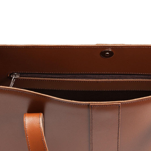 Close-up of a brown leather bag with a zipper