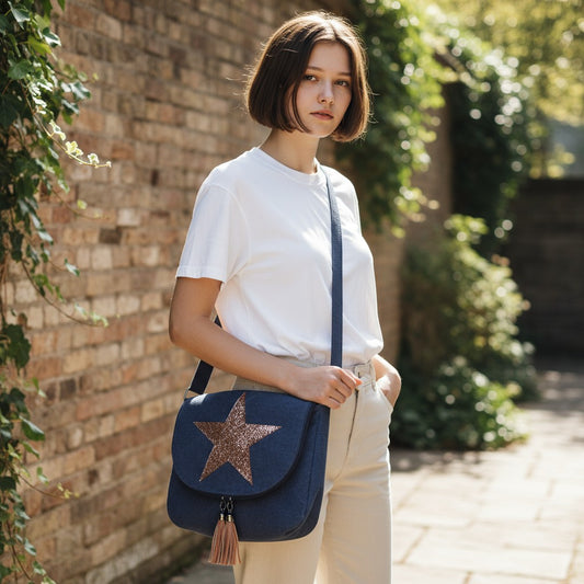 Woman holding a navy blue bag with a star design outdoors.