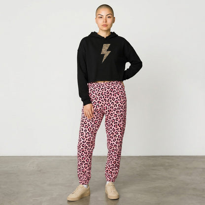 Person wearing a black hoodie with a leopard print design and pink leopard print pants on a plain background
